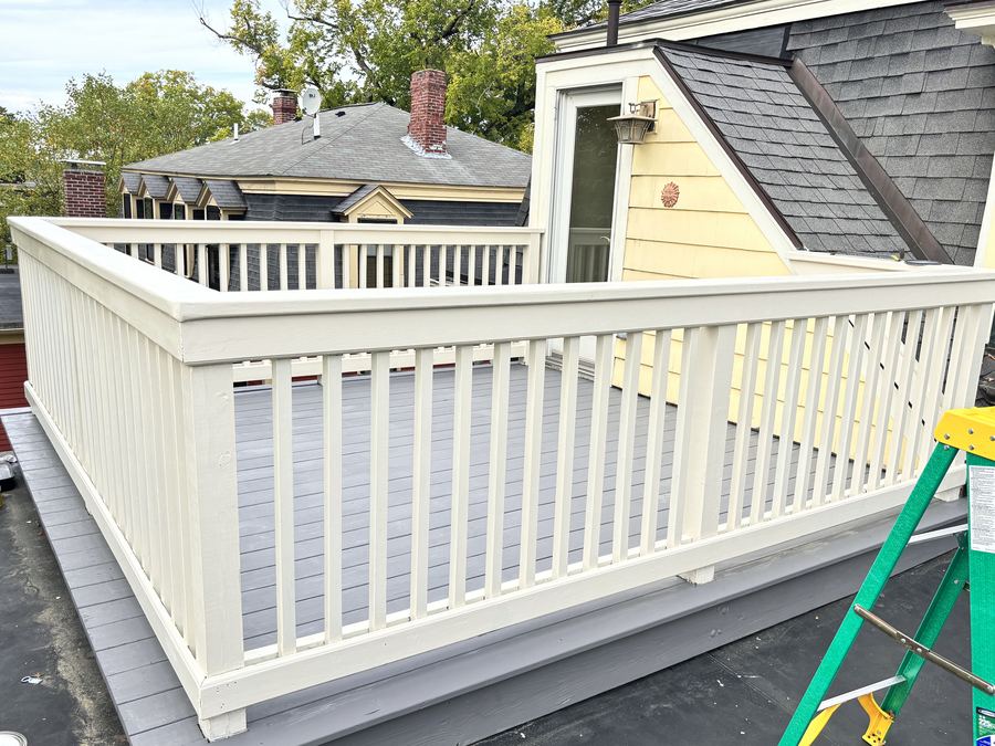 After: roof deck railing painted white with composite decking — Crafted Edge Construction